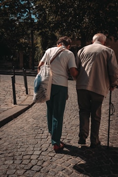man in brown shirt and blue denim jeans standing beside woman in white long sleeve shirt