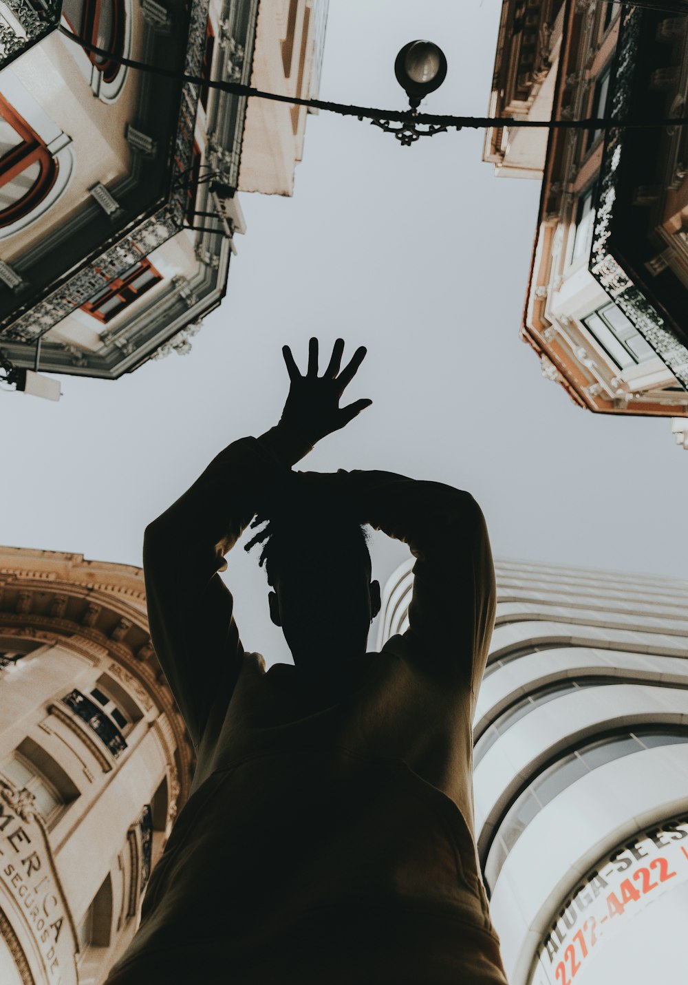 man in black hoodie raising his hands