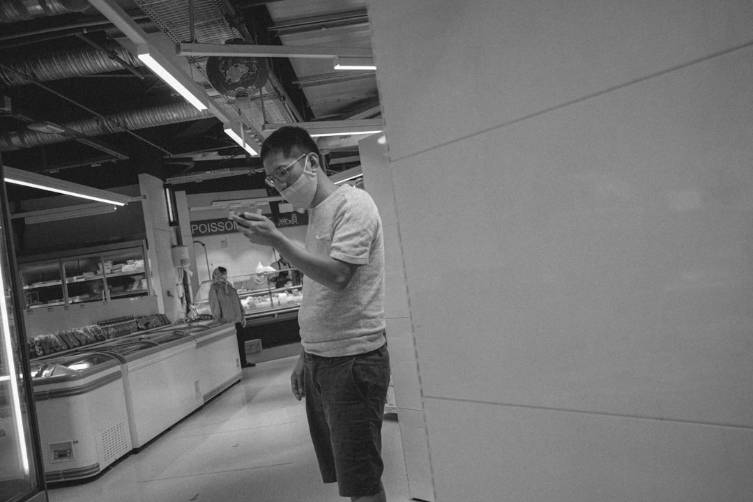 man in white t-shirt and gray pants standing in front of counter