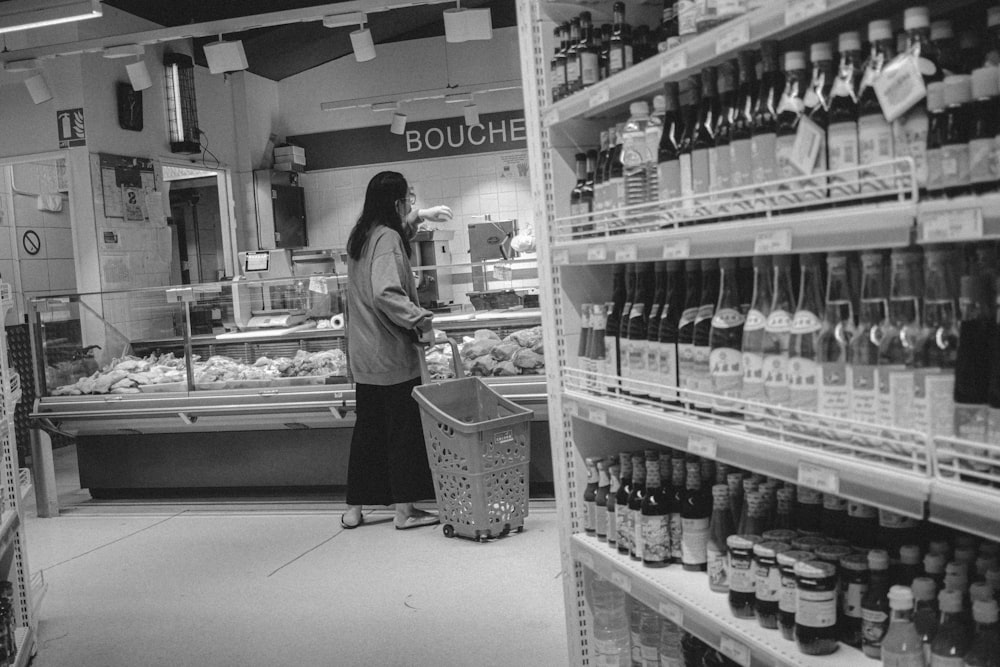 woman in black jacket standing in front of white display counter