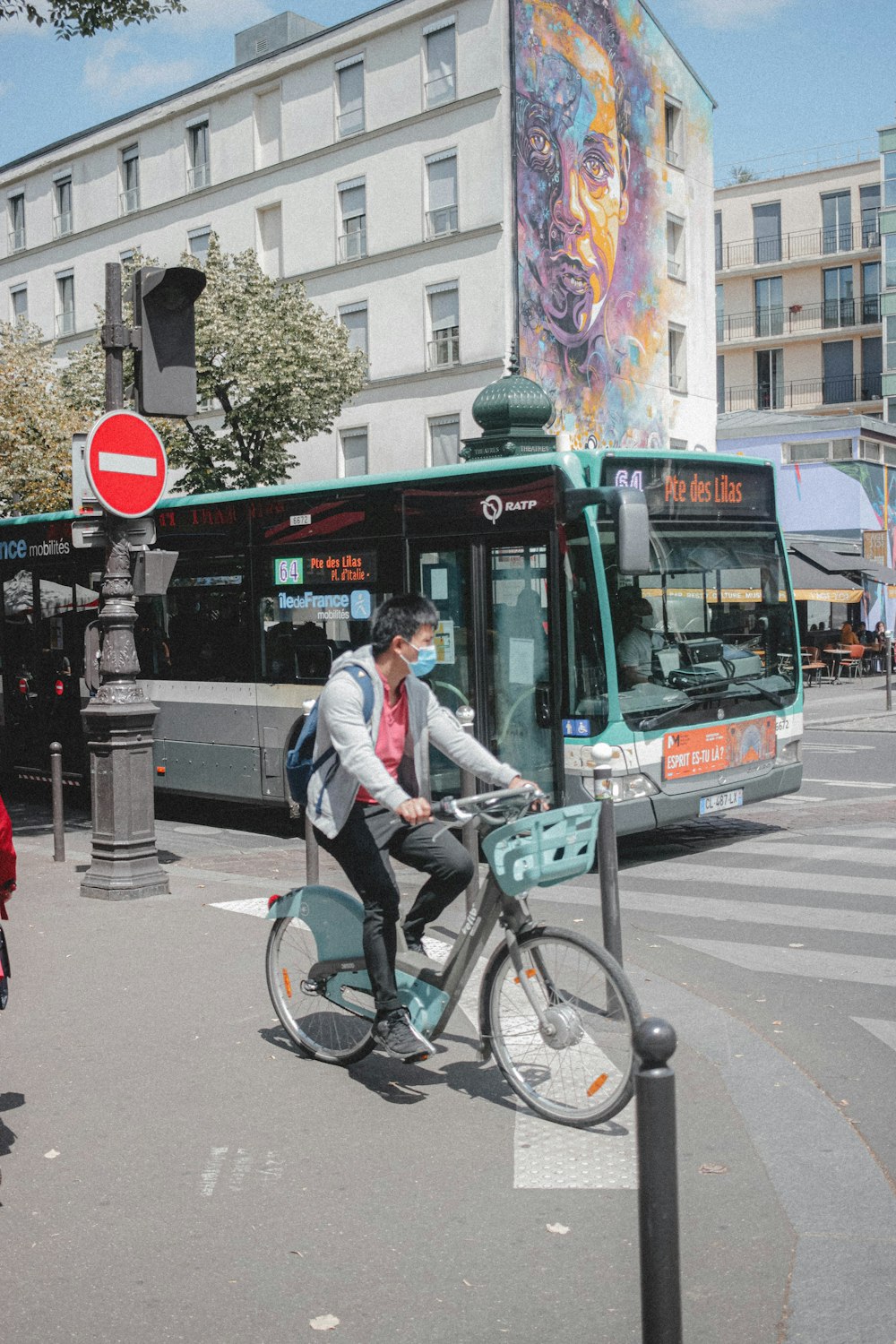 man in gray jacket riding on bicycle on road during daytime