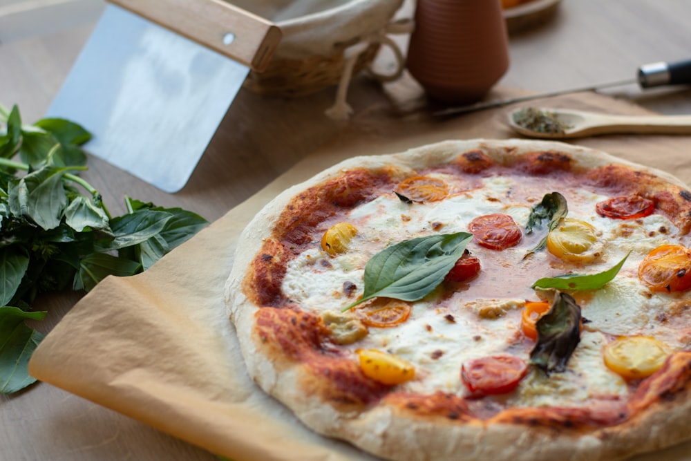 pizza on white paper beside green leaf