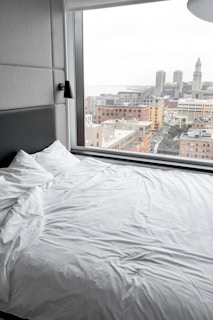 white bed linen near window