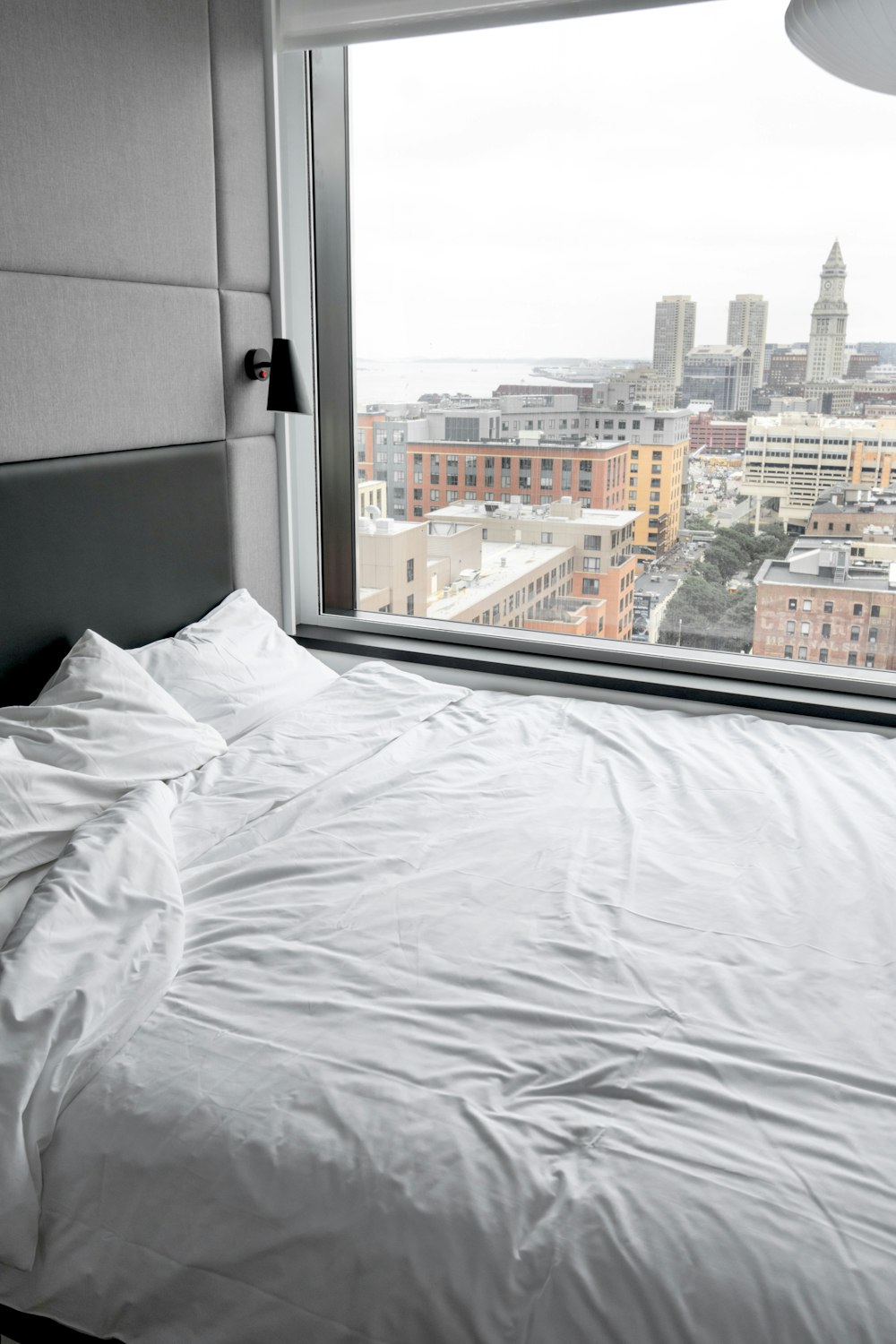 white bed linen near window