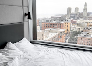 white bed linen near window