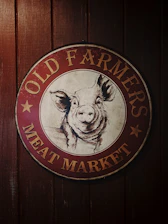 A friendly farmer showing fresh pork cuts at a sunny South Carolina farm.