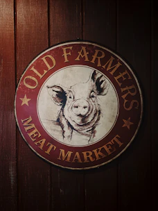 A friendly farmer showing fresh pork cuts at a sunny South Carolina farm.