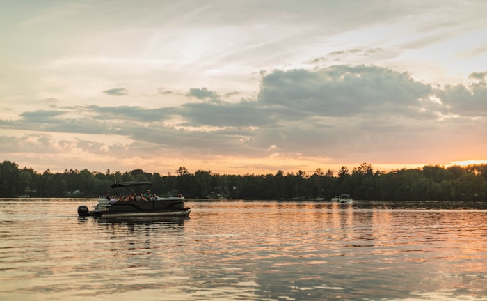 Sunset casting golden light over West Fox Lake with a pontoon boat docked nearby.