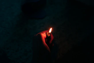 person holding lighted cigarette stick