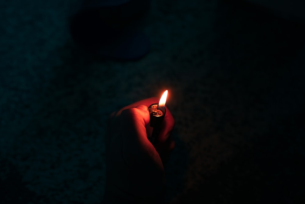 person holding lighted cigarette stick