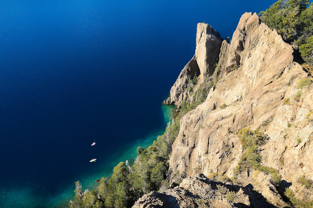 body of water near rocky mountain during daytime