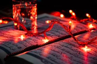 A peaceful study corner with an open Quran and a glowing lantern.