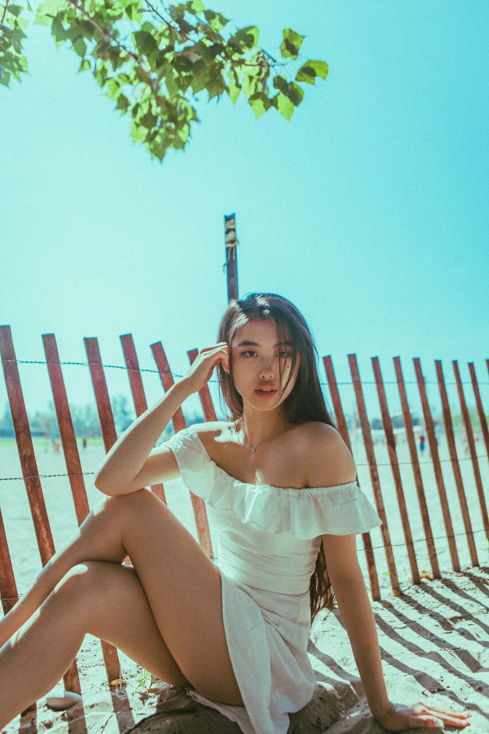 woman in white dress sitting on brown wooden bench