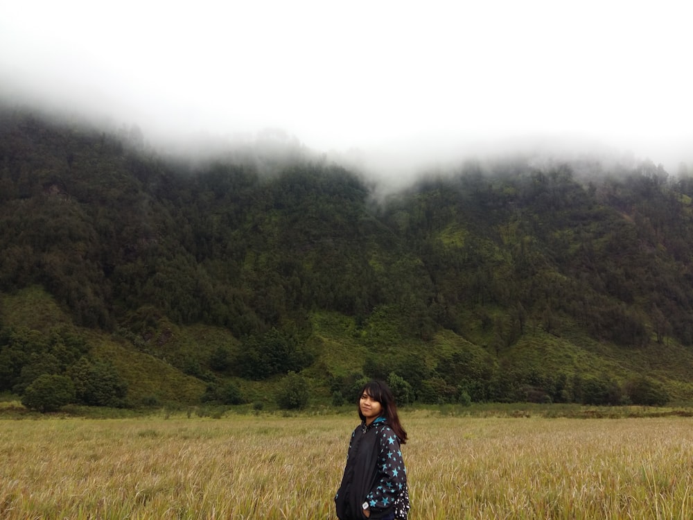 a woman standing in a field of tall grass