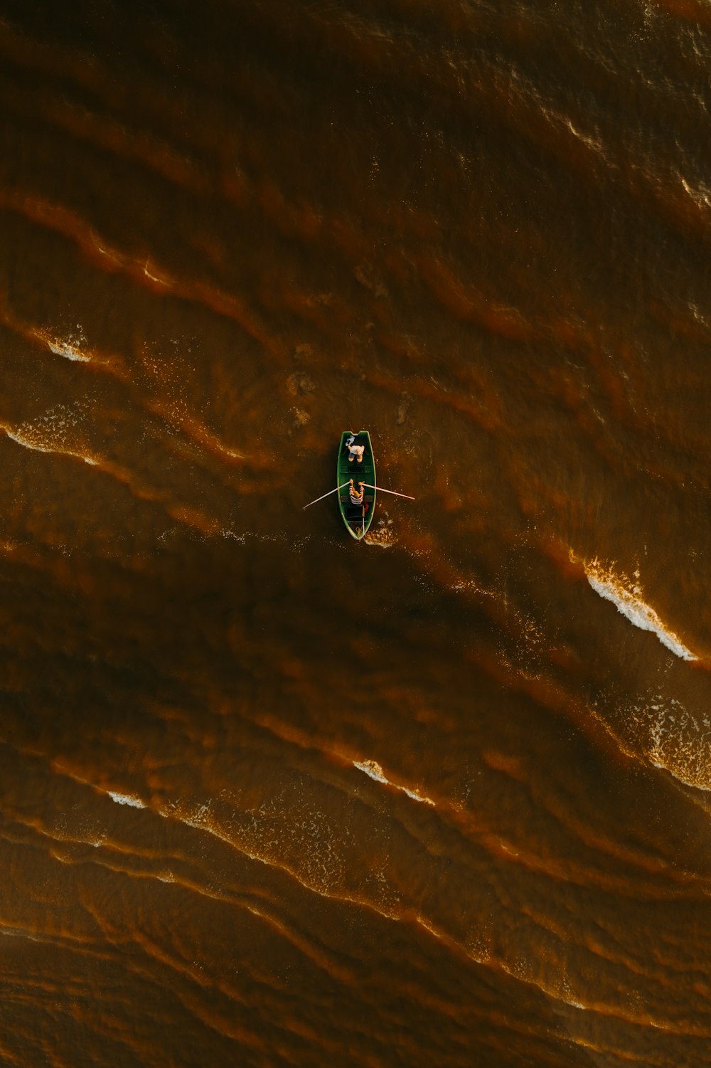 person in red and black jacket riding on blue and black board on white sand during