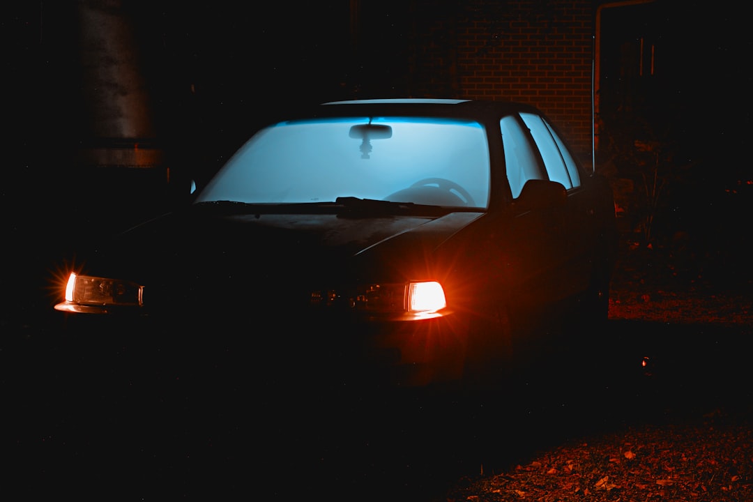 車 ライト 片方だけ black car parked in front of white building