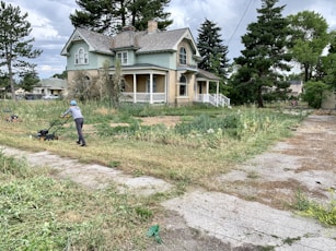 Yard cleanup example image with worker mowing the lawn