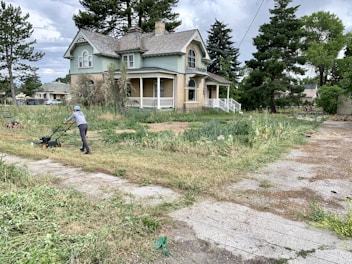 Yard cleanup example image with worker mowing the lawn