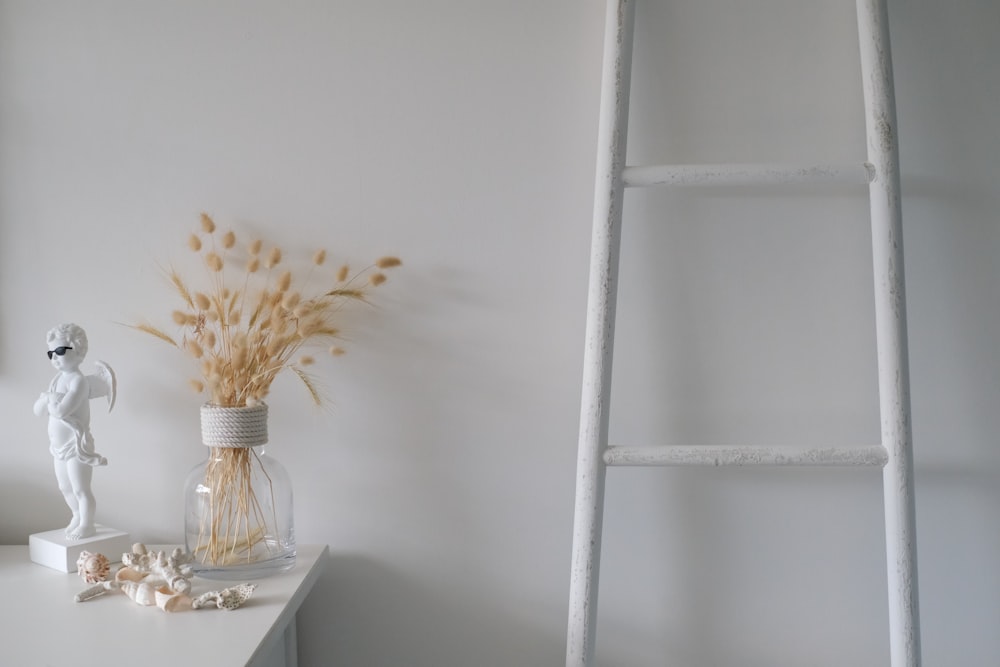 white flowers in clear glass vase on white table