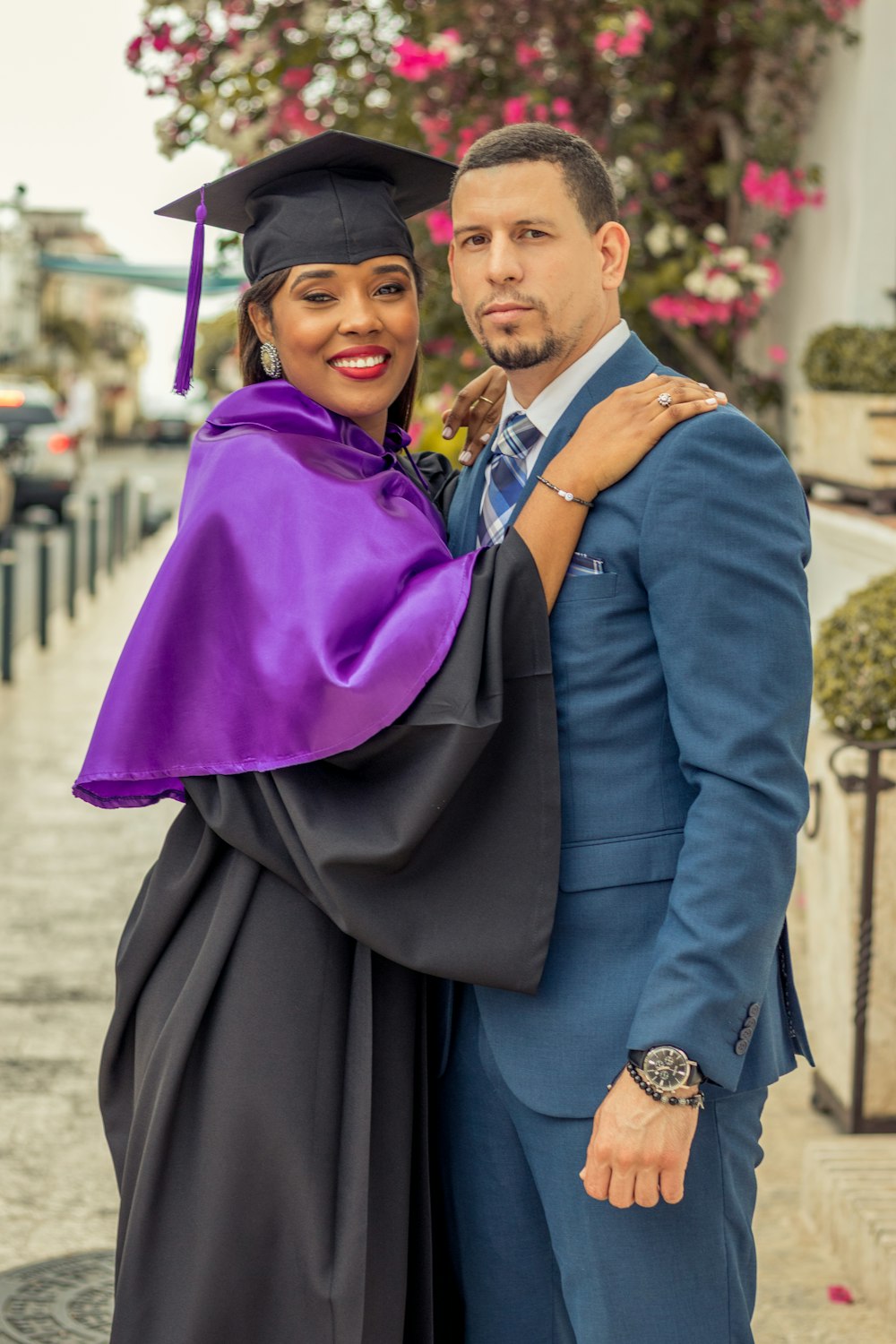 smiling woman in black long sleeve dress and purple academic gown