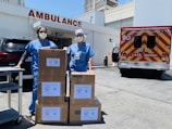 man in blue polo shirt standing beside brown cardboard boxes