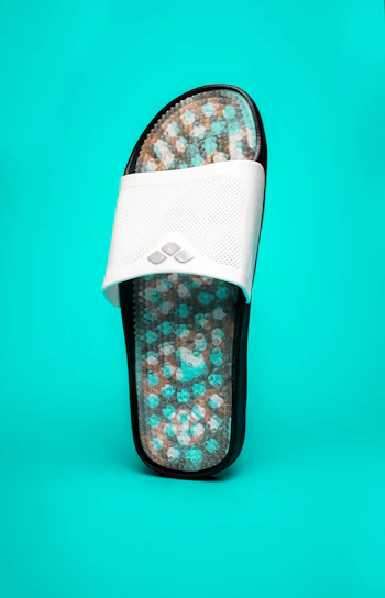 Close-up of a stylish blue anabela sandal with delicate straps, placed on a white background.