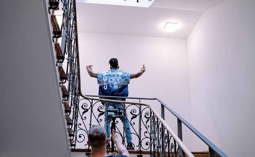 boy in blue t-shirt standing on staircase