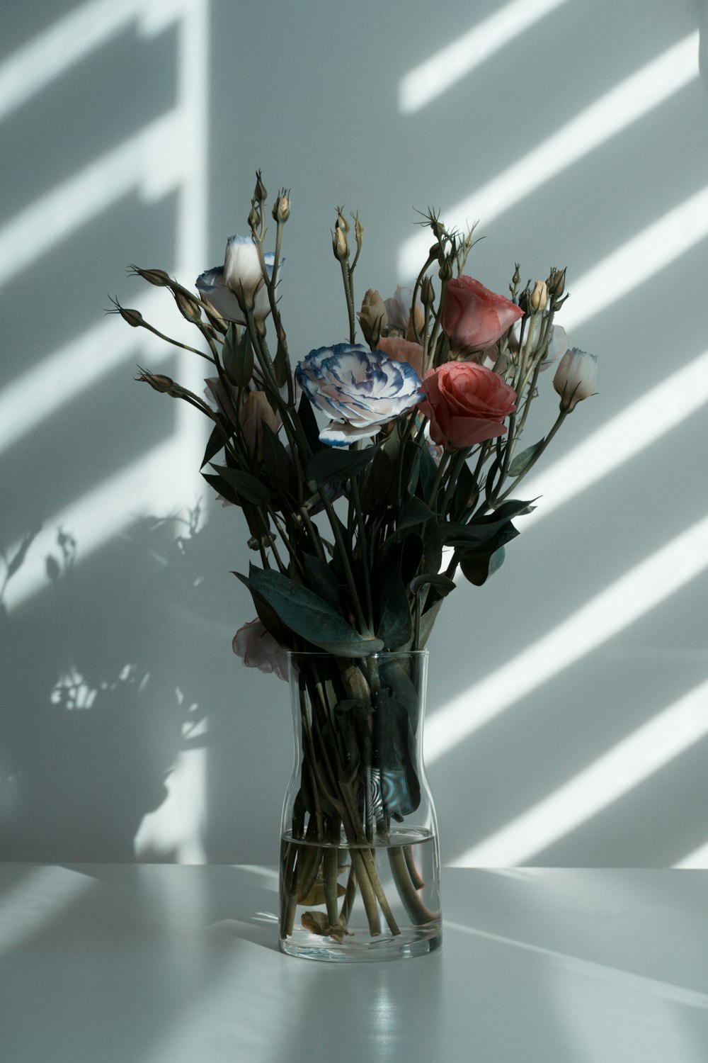 red and yellow roses in clear glass vase