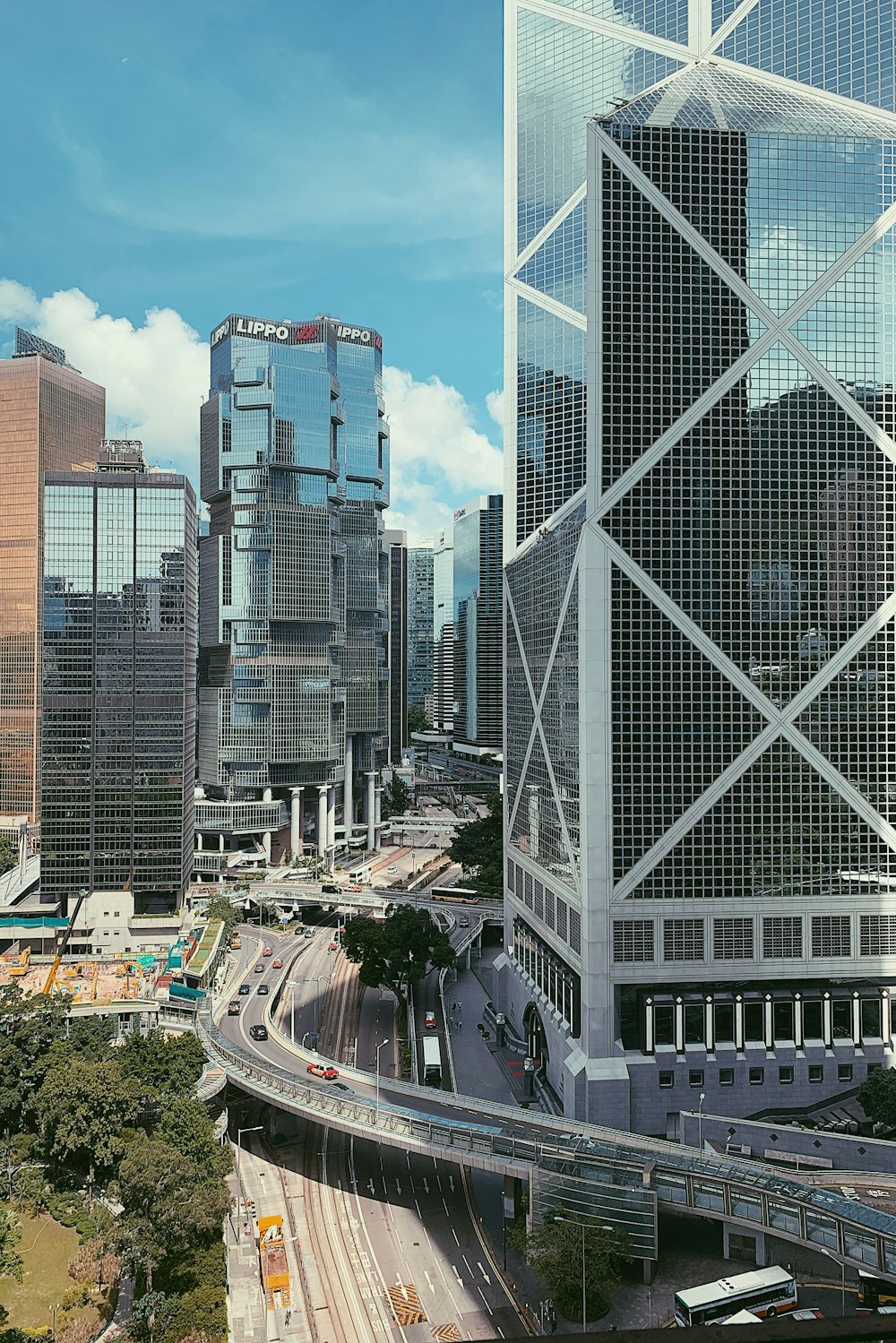 cars on road between high rise buildings during daytime