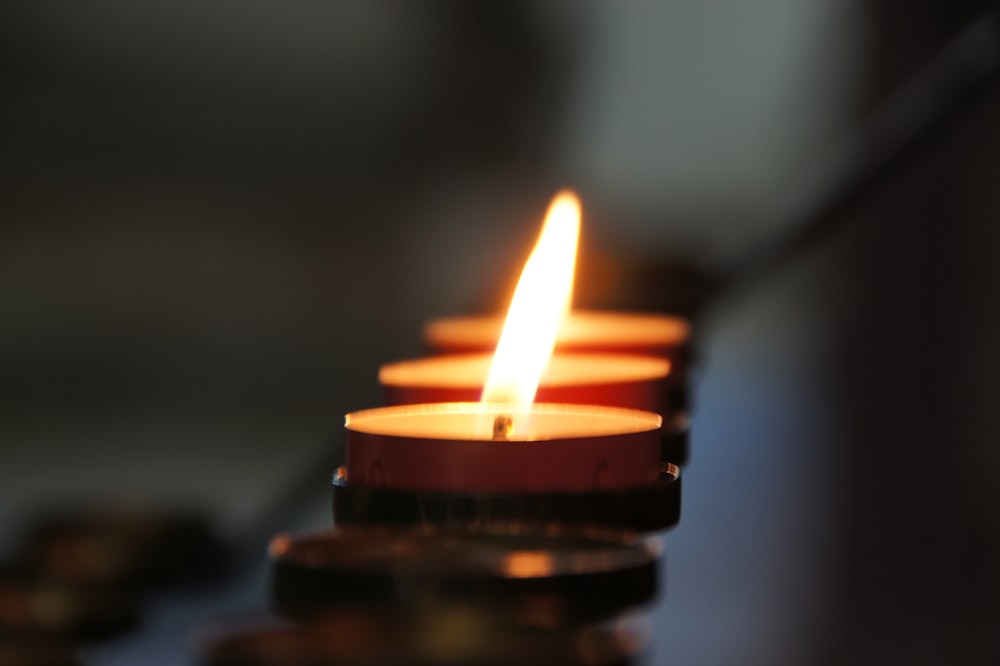 lighted candle in brown metal candle holder