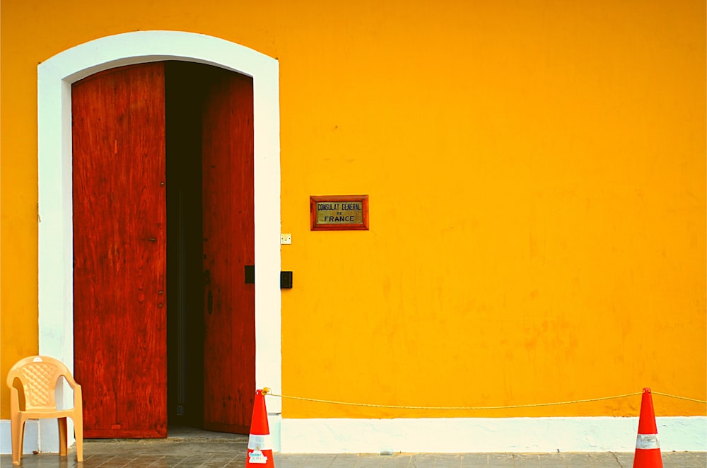 brown wooden door near white and brown concrete wall