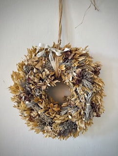 A collection of natural, chemical-free dried flower wreaths hanging on a wall