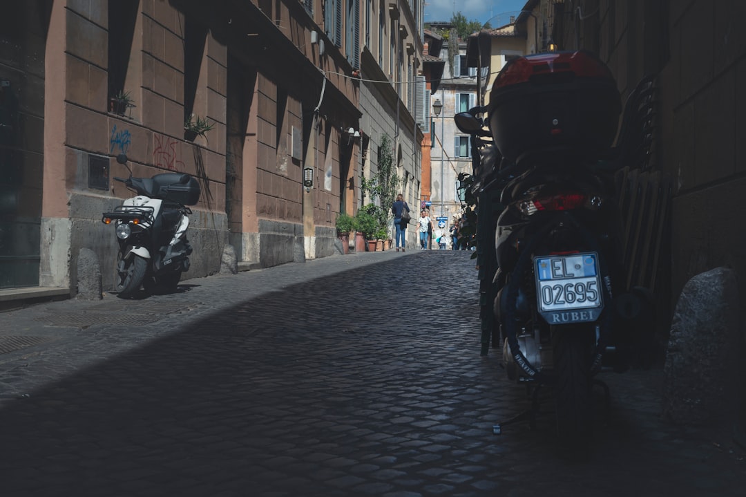 black motorcycle parked beside brown brick building