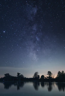 The Southern Cross constellation shining brightly over a calm lake reflecting the night sky