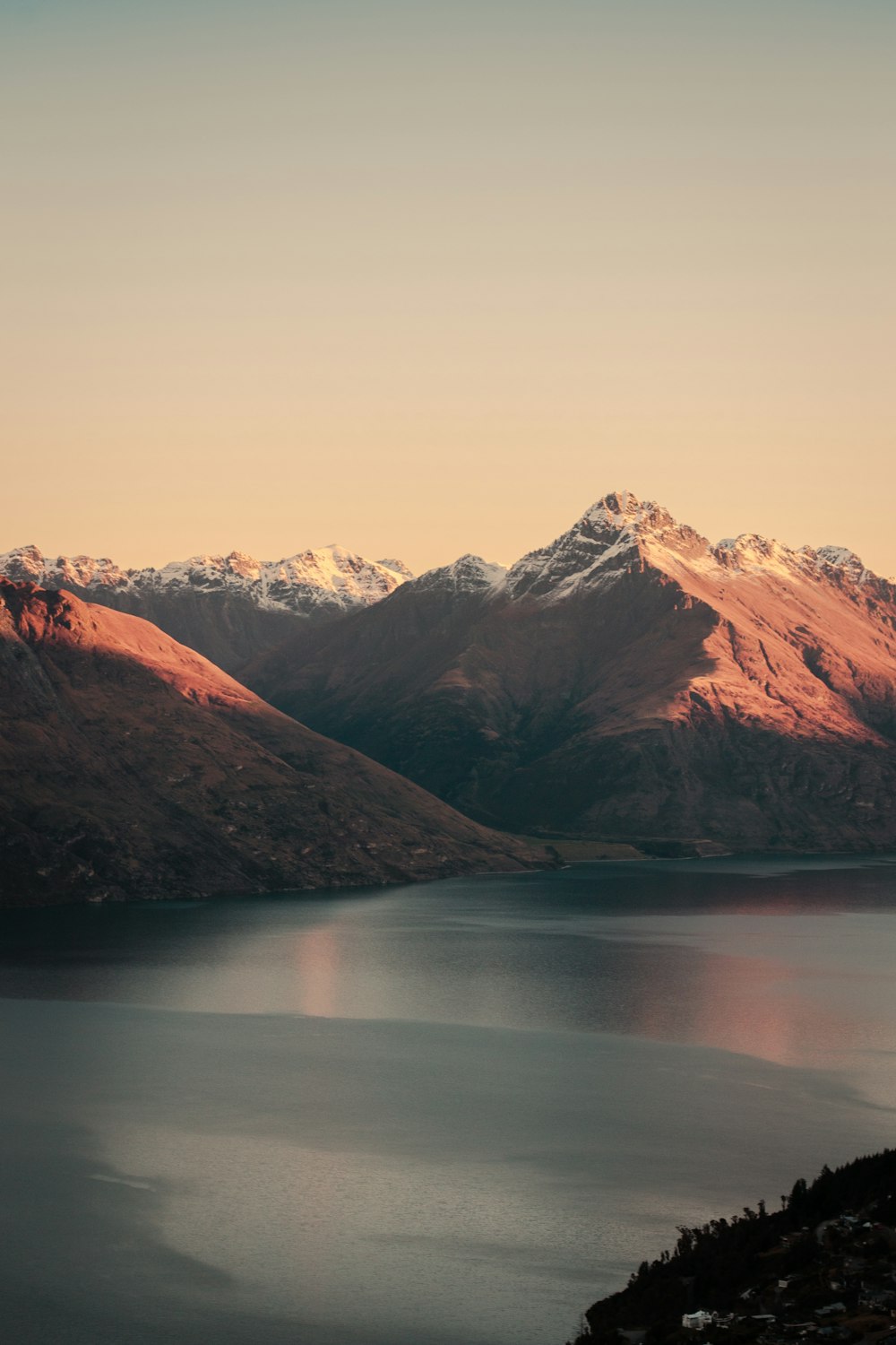 brown and white mountains beside body of water during daytime