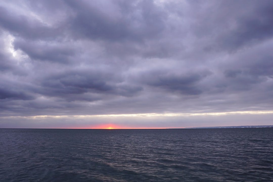 body of water under cloudy sky during daytime