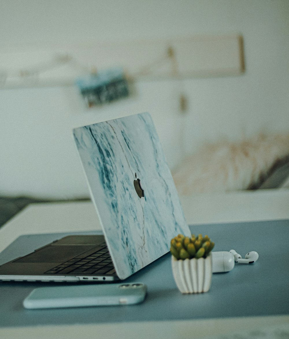 silver macbook on white table