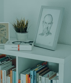 white framed woman portrait on white wooden shelf