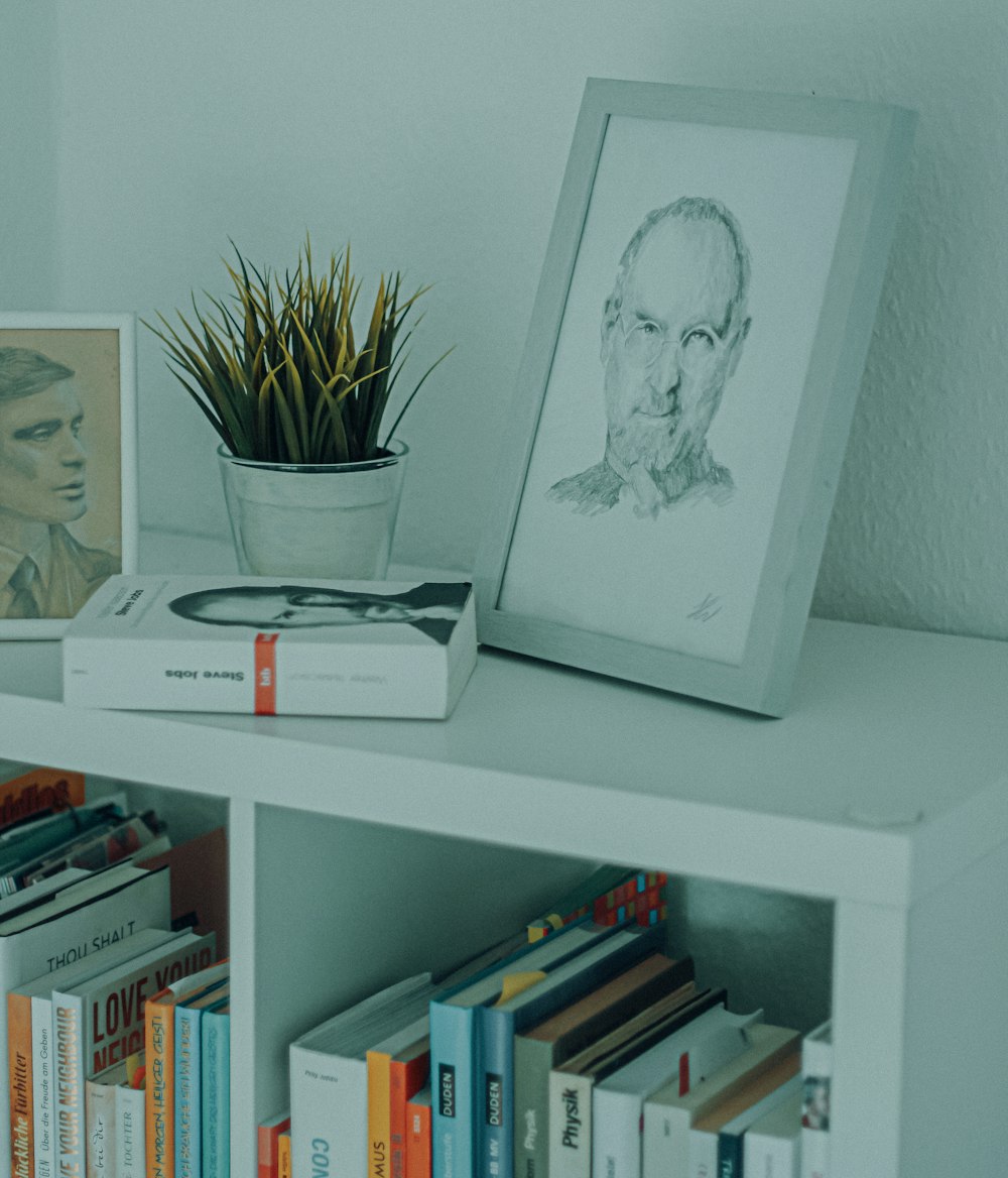 white framed woman portrait on white wooden shelf