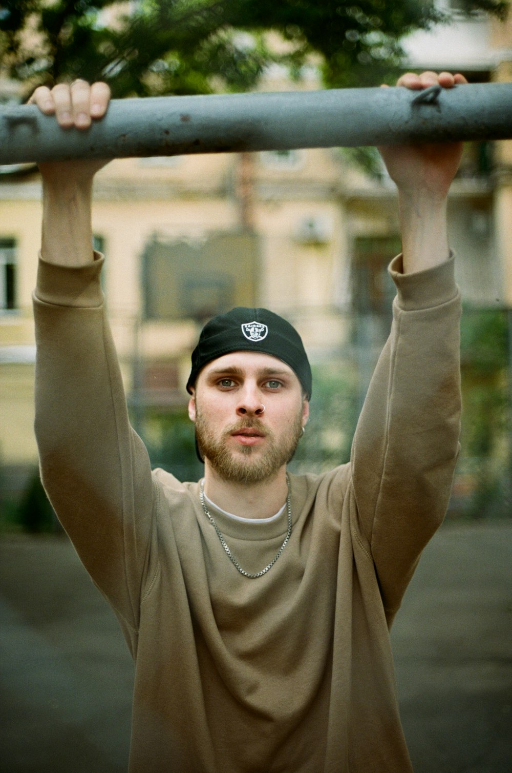 man in white crew neck t-shirt wearing black cap raising his right hand