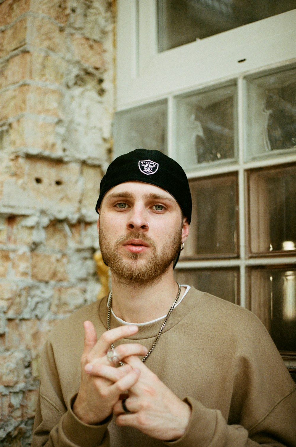 man in brown crew neck shirt wearing black cap