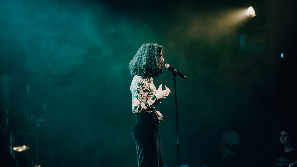 woman in white and black floral long sleeve shirt singing