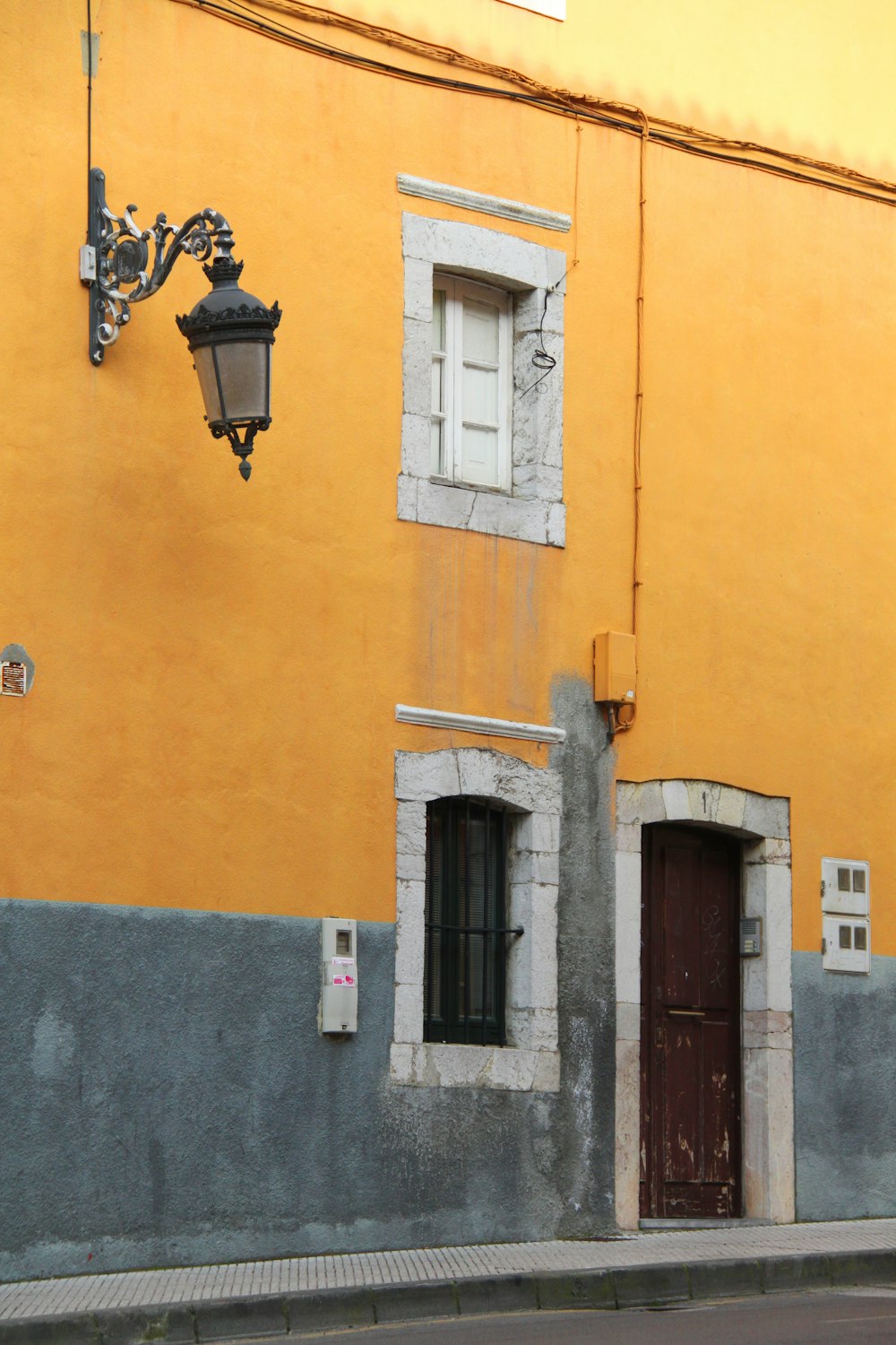 black sconce lamp on yellow concrete wall