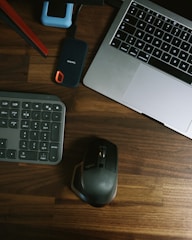 black and gray cordless computer mouse beside black and red power bank