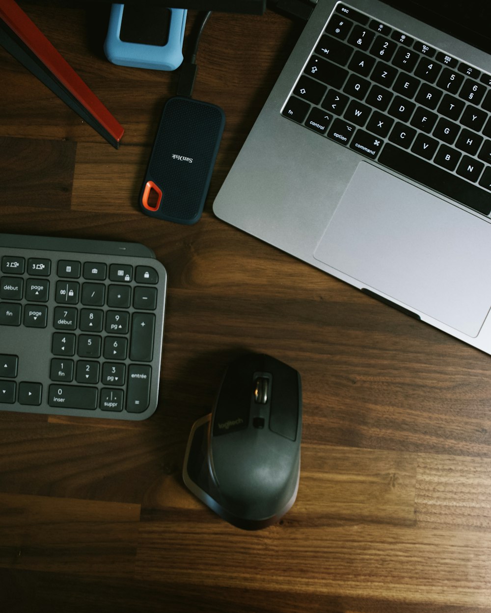 black and gray cordless computer mouse beside black and red power bank