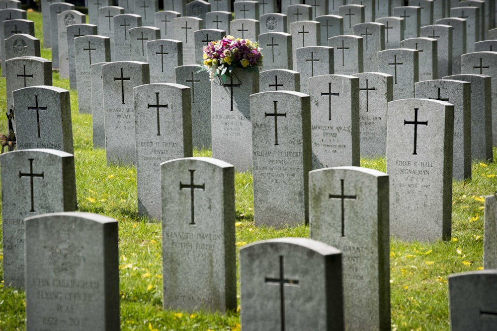 gray cross on green grass field during daytime