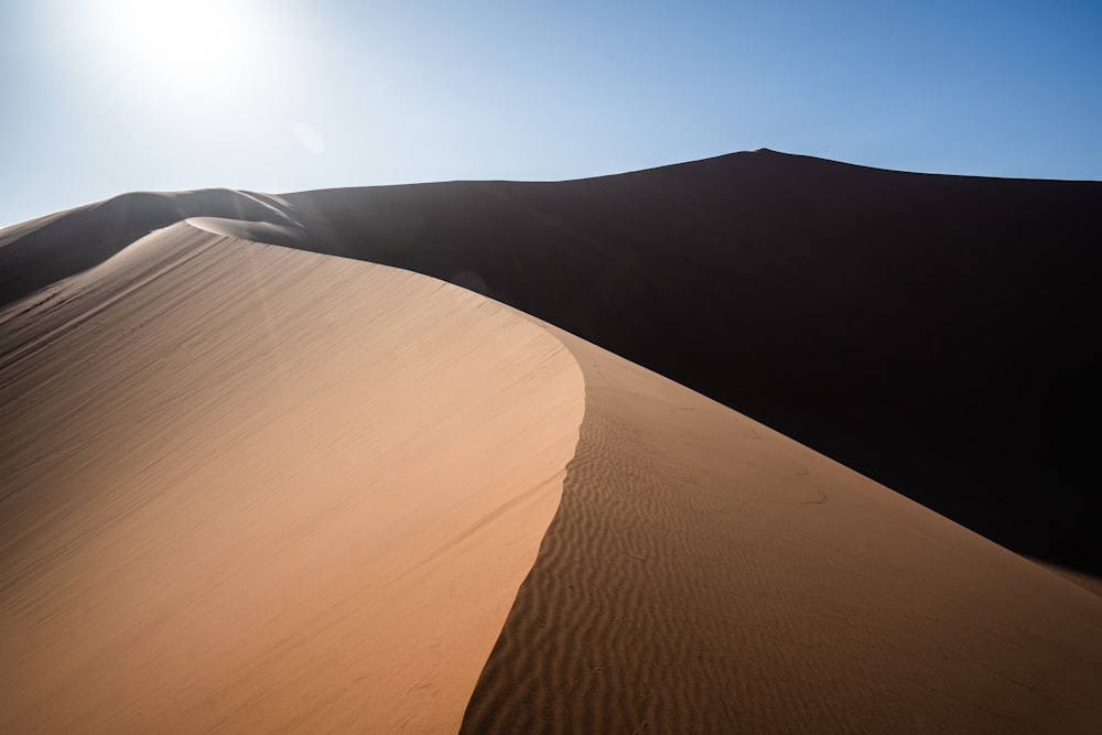 person walking on sand dunes during daytime