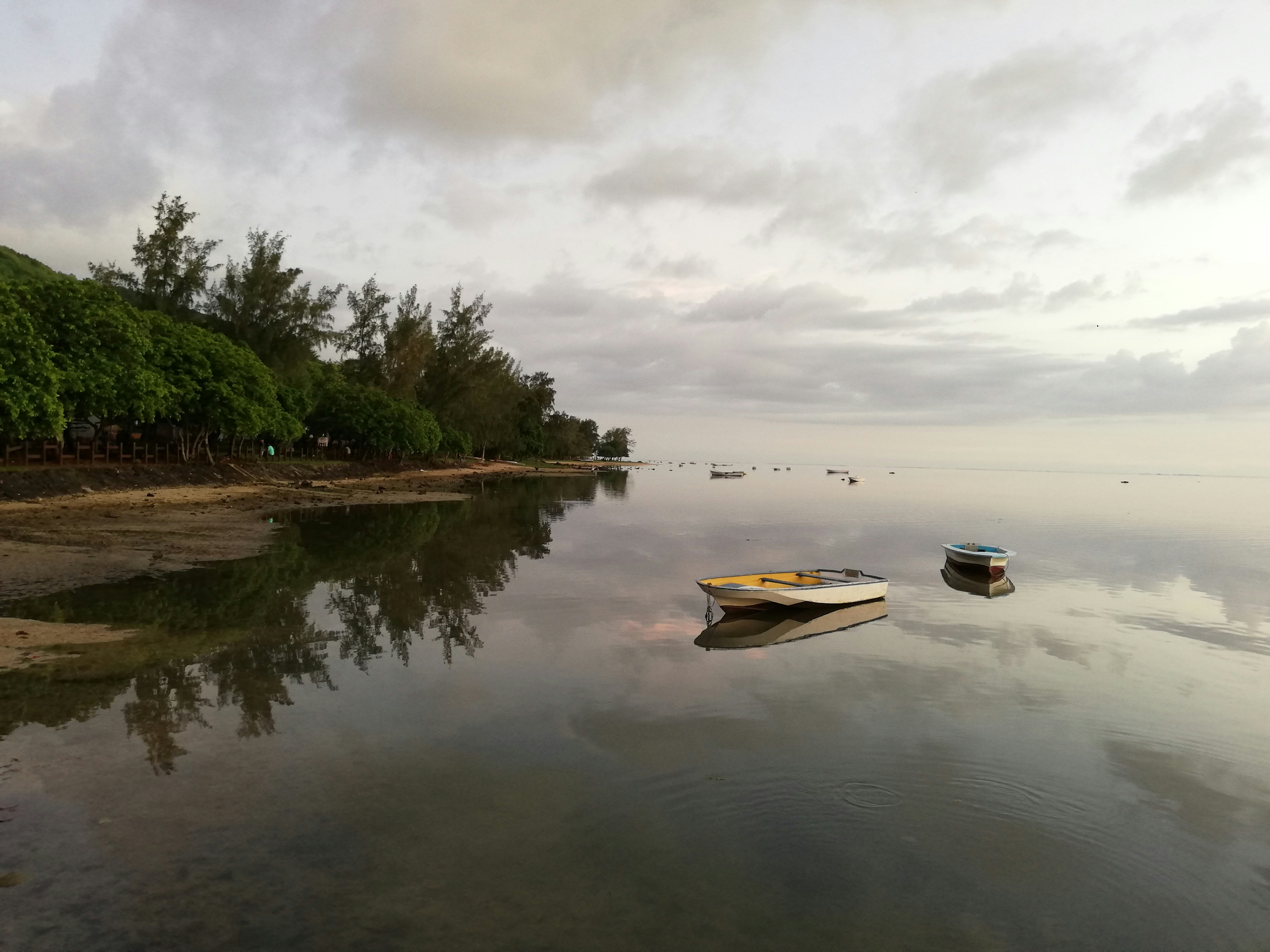 white and brown boat on water under cloudy sky during daytime