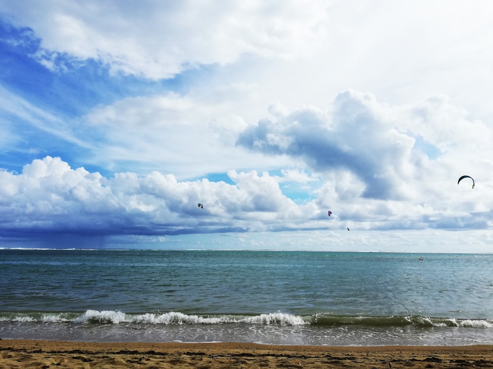 blue sea under white clouds and blue sky during daytime