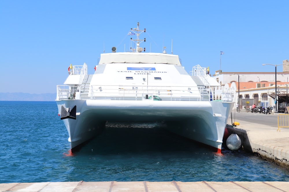 white yacht on sea under blue sky during daytime